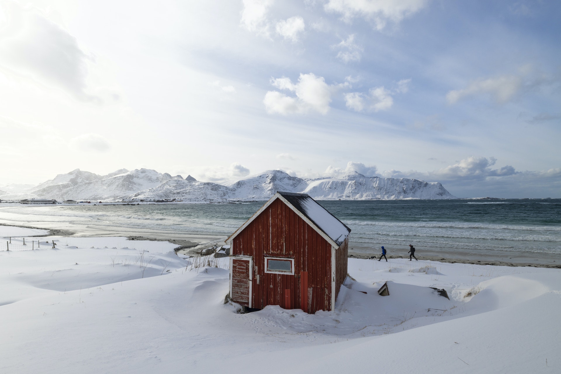 красная хижина Рорбуер на знаменитом пляже Рамбергстранда, Лофотенские острова, Норвегия, но покрытая снегом