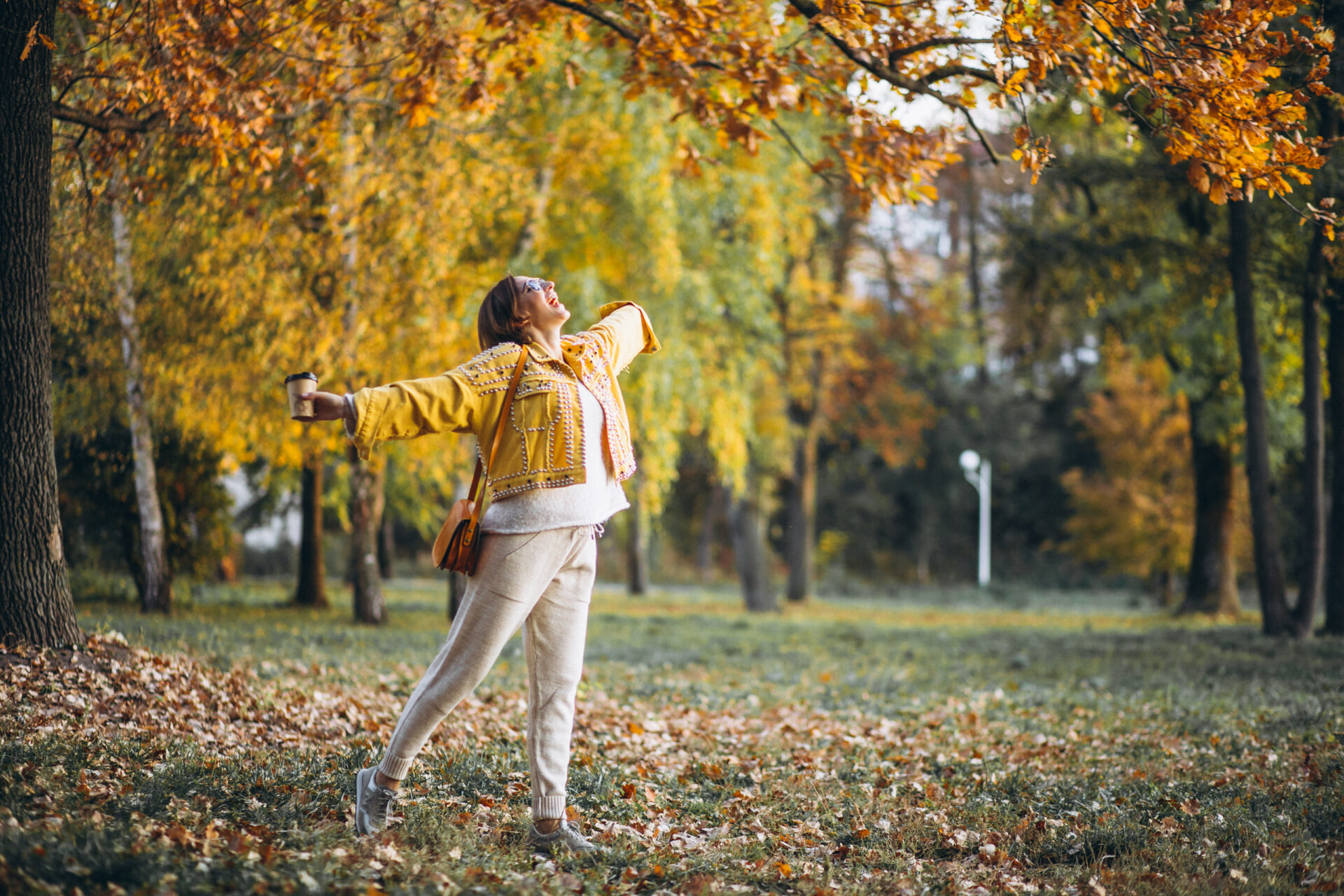 Young woman in an autumn park drinking coffee девушка осенью